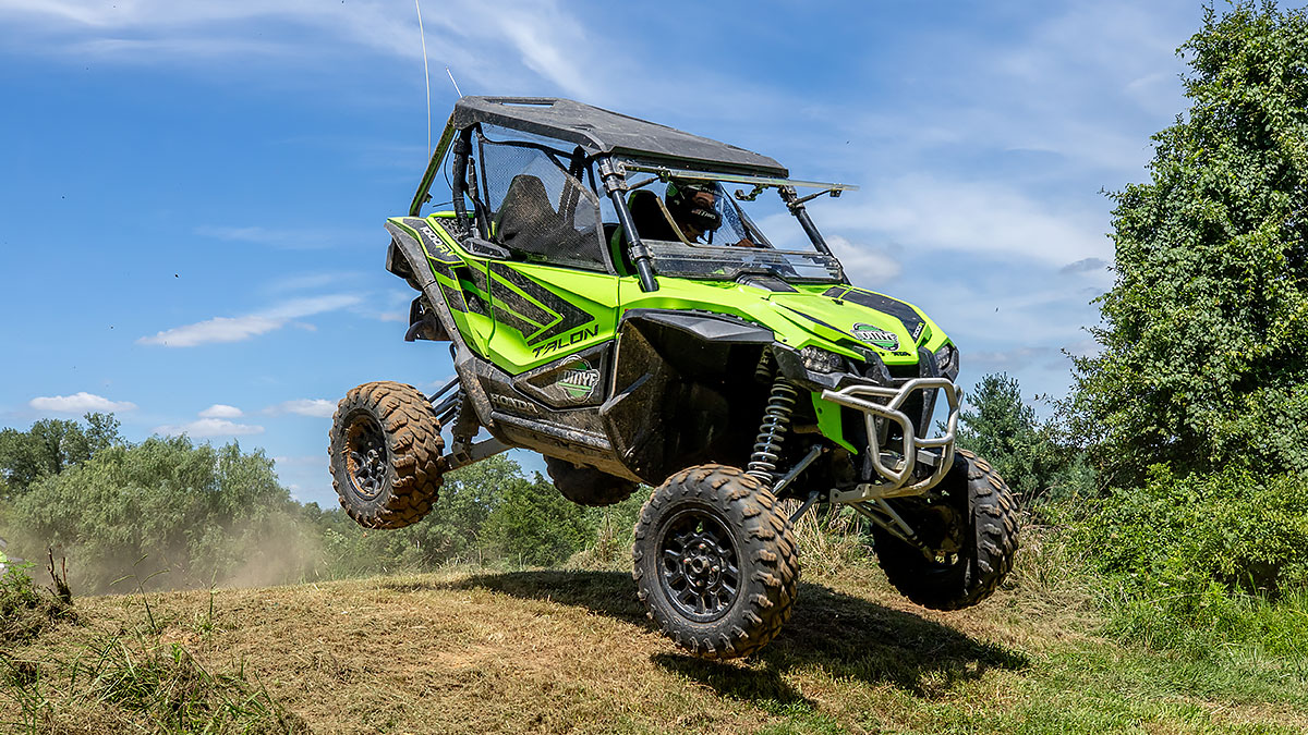 An Outdoor Motorsports Youth Foundation Baja racing vehicle jumping a hill outdoors
