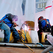 Two operators weld on an elevated construction jobsite