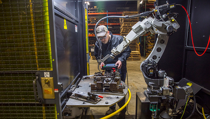 Operator sets up a robotic welding cell