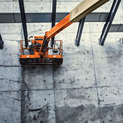 Welder works in an aerial lift platform on a structural jobsite