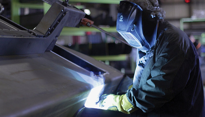 Closeup of operator welding in a manufacturing environment