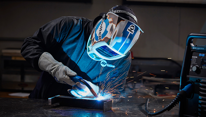 Welder MIG welding wearing a Miller welding helmet