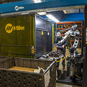 Operator makes adjustments with a tablet screen in a robotic weld cell