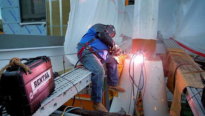 Welder at Apex Steel welding with rented welding equipment