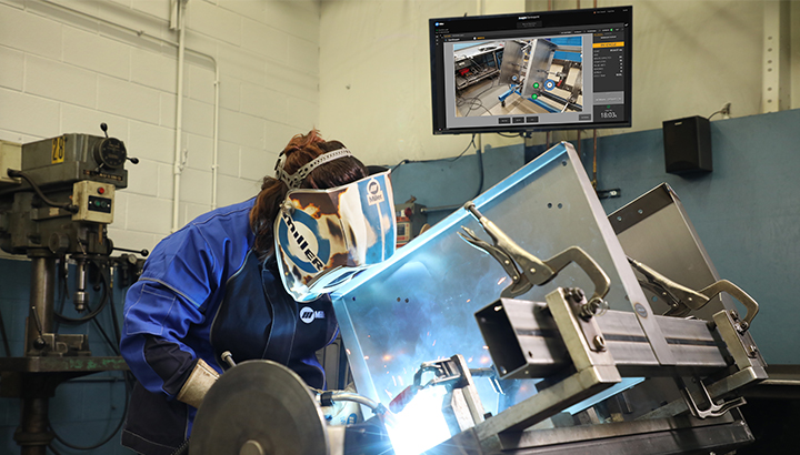  Operator welds with a screen image in the background showing real-time feedback 