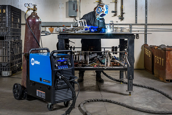 A person pulse MIG welding aluminum with a Millermatic 355 MIG welder