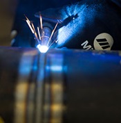 A welder completes a pass on carbon steel pipe