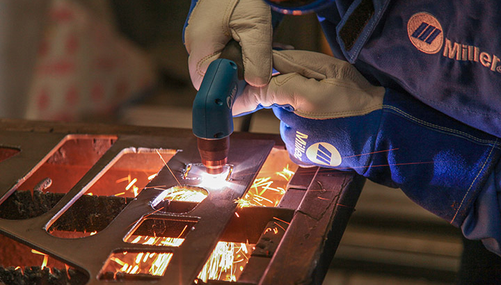 closeup of a person cutting metal with a plasma cutting torch