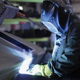 Welder MIG welding in a manufacturing facility