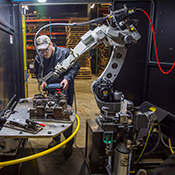 Operator sets up a robotic welding cell