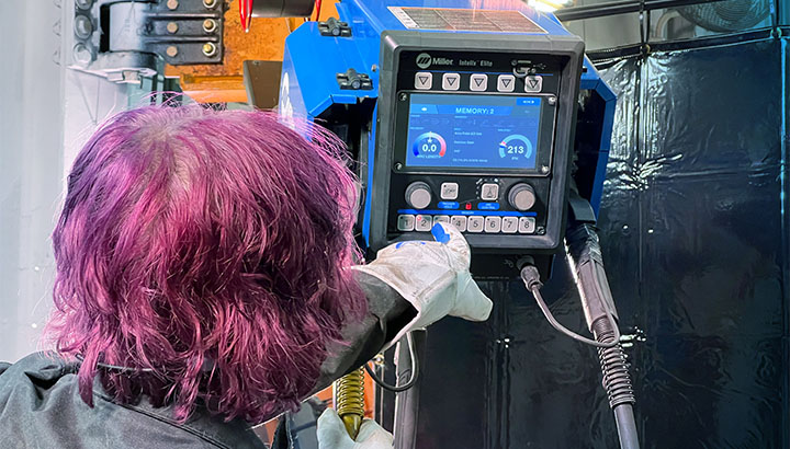 Operator adjusts settings on the wire feeder interface