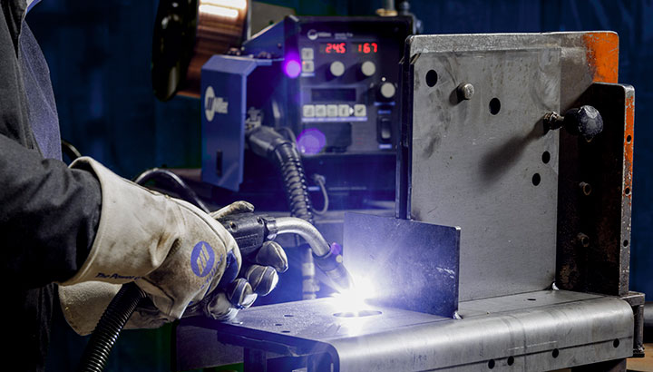 Close up of an operator MIG welding in a manufacturing environment