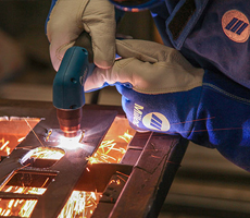 Closeup of a person cutting metal with a plasma cutting torch