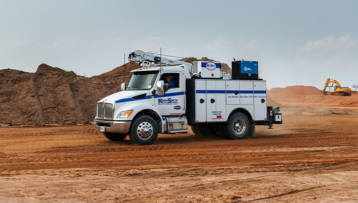 Engine-driven welder mounted on a work truck driving through a jobsite