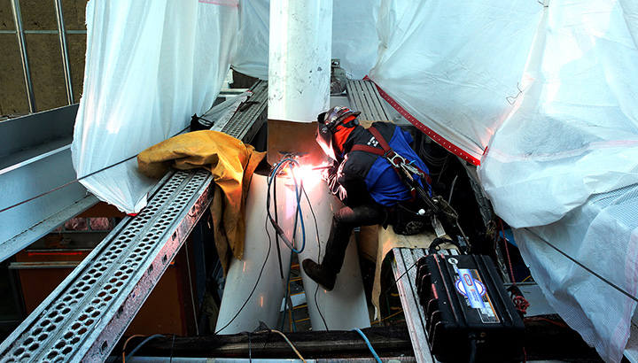 A welder on a structural construction jobsite using a Miller ArcReach 16.