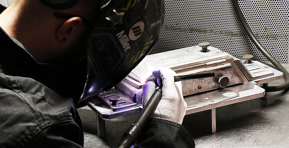 Operator TIG welding at an aerospace manufacturing plant with a Dynasty® 400 TIG welder