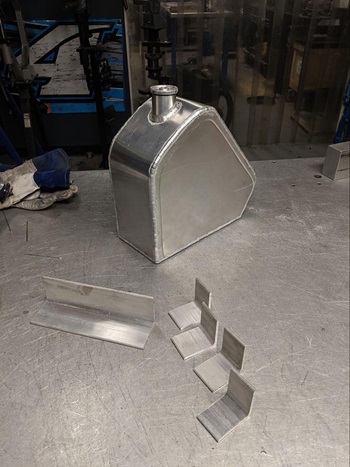 aluminum fuel tank with mounting brackets next to it