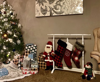 stocking holder stand next to a Christmas tree 