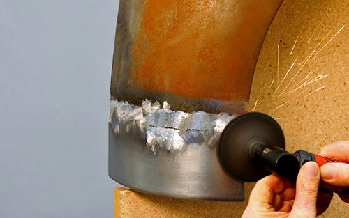 Welder using a disc grinder