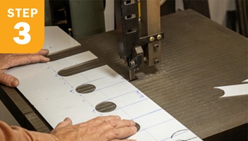 Operator cutting slots into metal piece with hole saw
