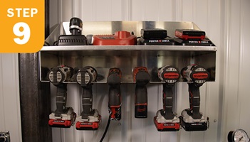 Shelf hanging on wall with cordless tools and batteries
