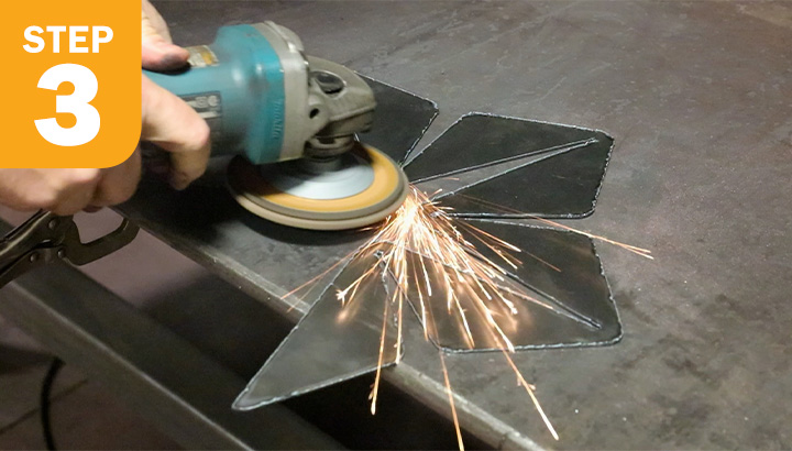 Close-up of grinder with flap wheel grinding sheet metal edges