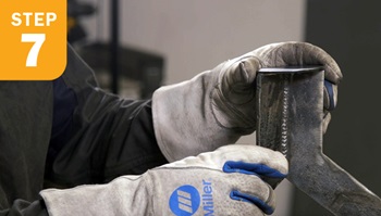 holding a small metal disk on top of a metal table base