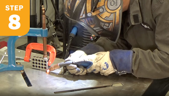 Welder welding two pieces together.