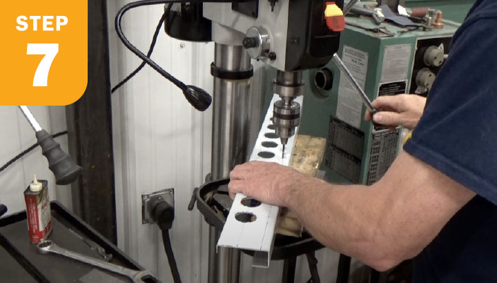 Operator drilling small holes in metal piece