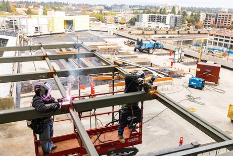 Two operators welding a building structure
