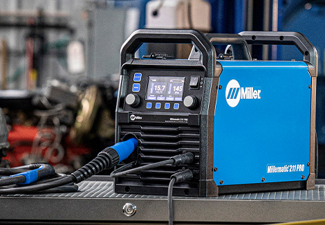 Millermatic 211 PRO on a workbench in a shop environment.