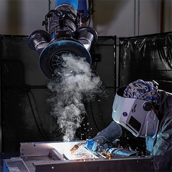 A person MIG welding and using ZoneFlow™ technology fume extraction